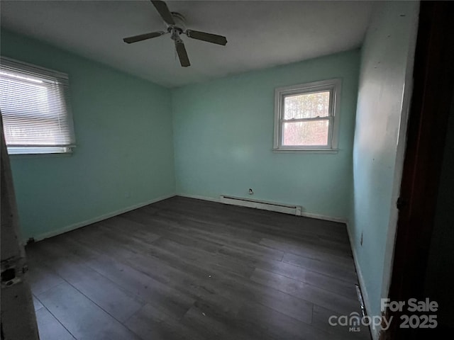 empty room with baseboard heating, dark wood-type flooring, and ceiling fan