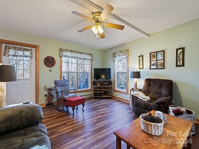 living room with a wealth of natural light, dark hardwood / wood-style flooring, ceiling fan, and a textured ceiling