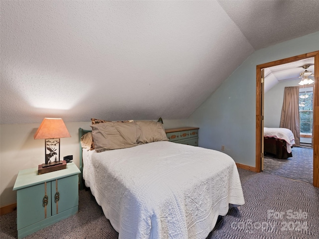 bedroom featuring a textured ceiling, dark carpet, and lofted ceiling