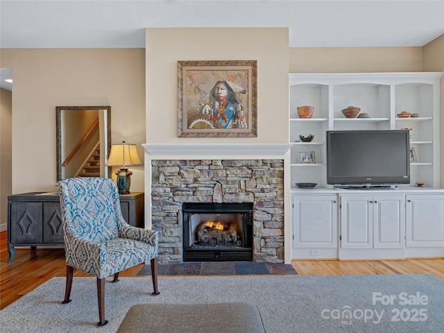 20 Red Plum Ln, Black Mountain, NC 28711 - living room featuring a stone fireplace, light wood-style flooring, and stairs