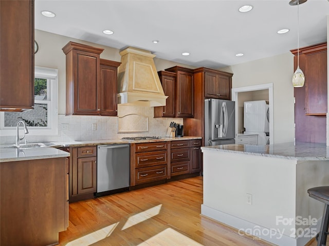20 Red Plum Ln, Black Mountain, NC 28711 - kitchen featuring light stone counters, light wood-style flooring, stainless steel appliances, a sink, and custom range hood