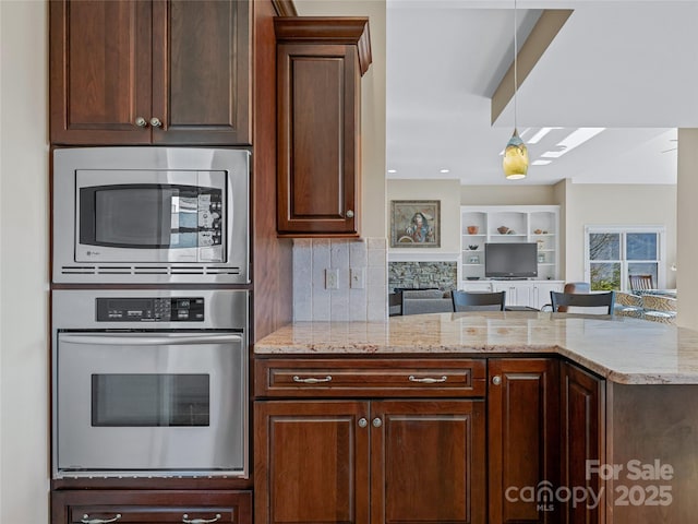 20 Red Plum Ln, Black Mountain, NC 28711 - kitchen featuring light stone counters, dark brown cabinetry, open floor plan, appliances with stainless steel finishes, and backsplash