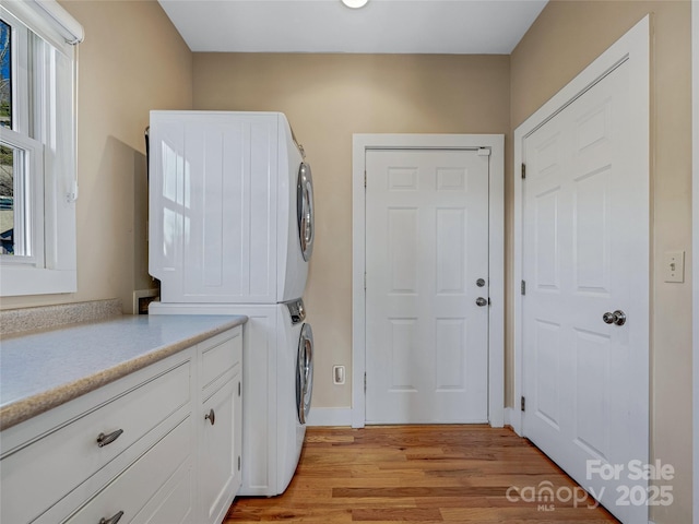 20 Red Plum Ln, Black Mountain, NC 28711 - washroom with stacked washer / drying machine, cabinet space, light wood-style flooring, and baseboards