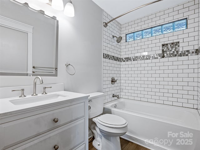 full bathroom featuring vanity, hardwood / wood-style floors, toilet, and tiled shower / bath