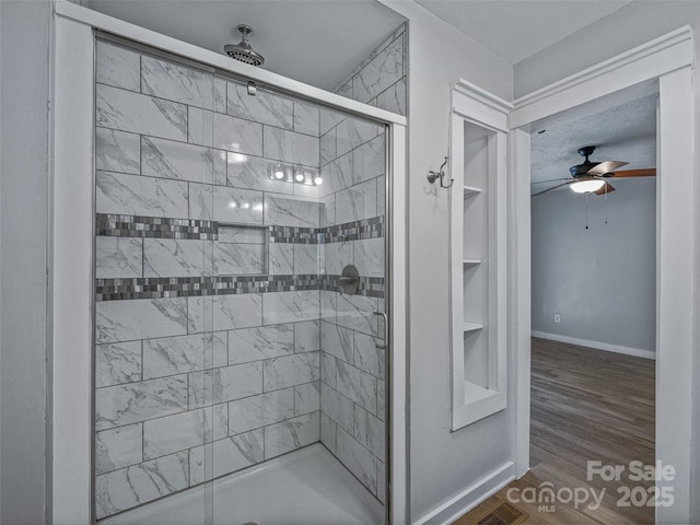 bathroom featuring hardwood / wood-style floors, a tile shower, and ceiling fan