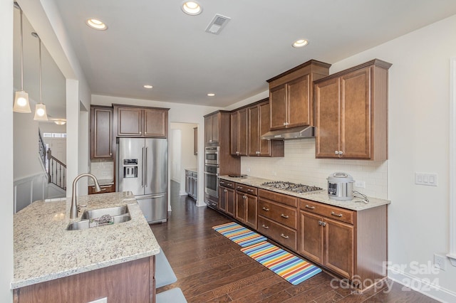 kitchen with dark hardwood / wood-style flooring, backsplash, stainless steel appliances, sink, and decorative light fixtures