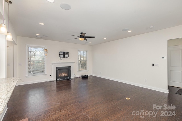 unfurnished living room featuring a healthy amount of sunlight and dark hardwood / wood-style floors