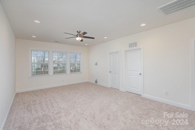 unfurnished room with ceiling fan and light carpet