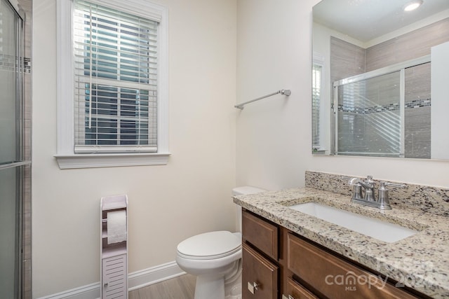 bathroom with vanity, hardwood / wood-style flooring, toilet, and a shower with door