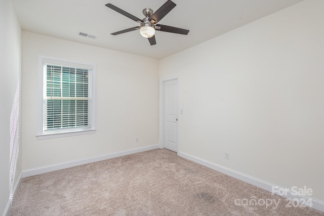 carpeted spare room with ceiling fan