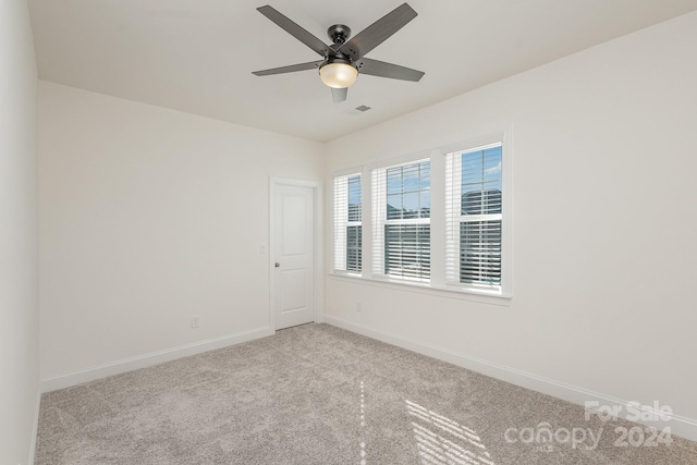 carpeted spare room featuring ceiling fan