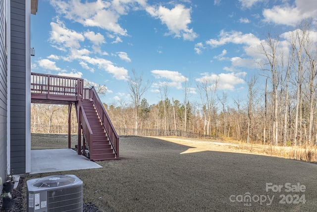 view of yard featuring cooling unit and a deck