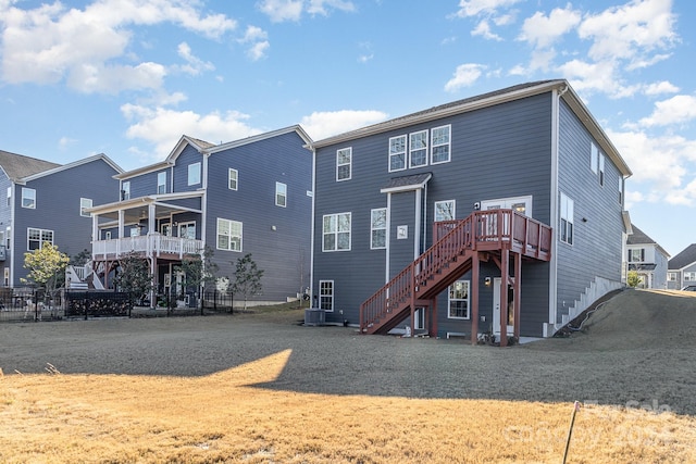 back of house featuring central AC unit and a lawn