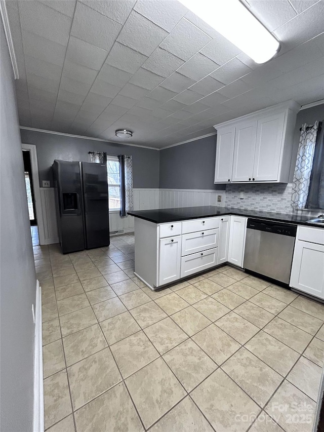 kitchen featuring black refrigerator with ice dispenser, stainless steel dishwasher, ornamental molding, light tile patterned floors, and white cabinetry