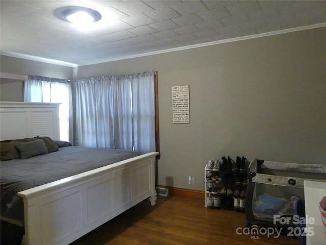 bedroom with crown molding and dark wood-type flooring