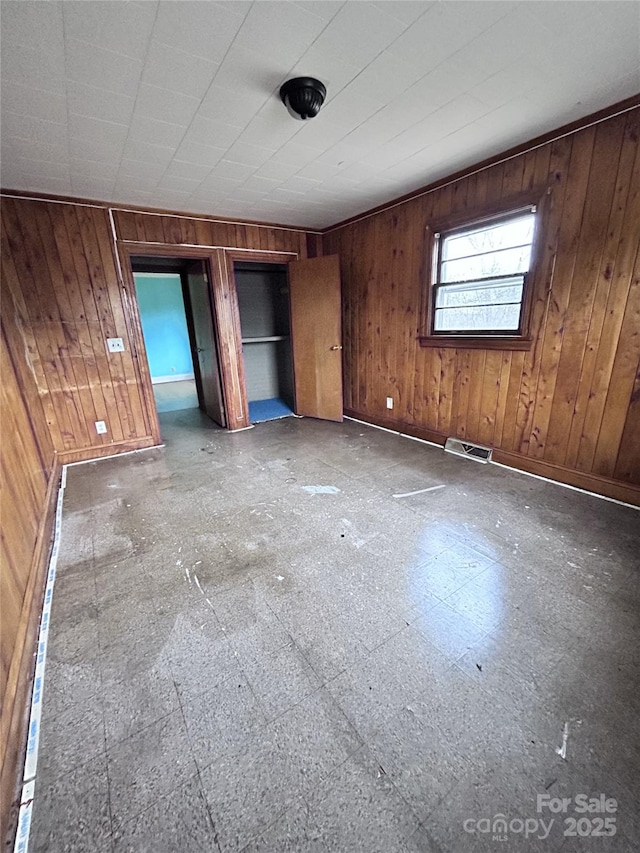 unfurnished bedroom with wooden walls