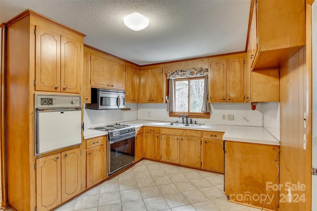 kitchen featuring sink, white oven, stove, a textured ceiling, and light tile patterned floors