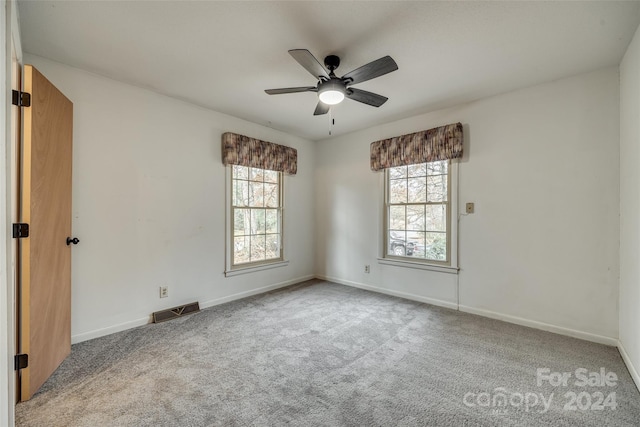 carpeted empty room with ceiling fan and a healthy amount of sunlight