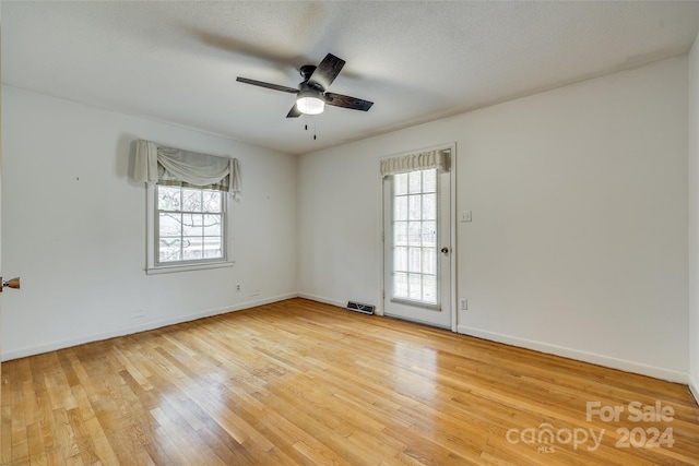 unfurnished room featuring hardwood / wood-style floors, ceiling fan, and a textured ceiling