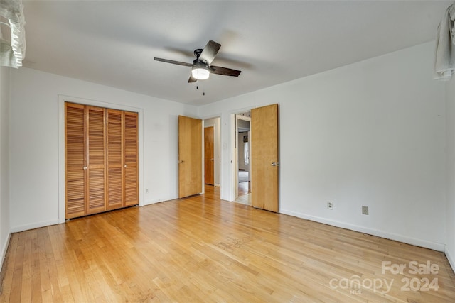 unfurnished bedroom with a closet, light hardwood / wood-style floors, and ceiling fan