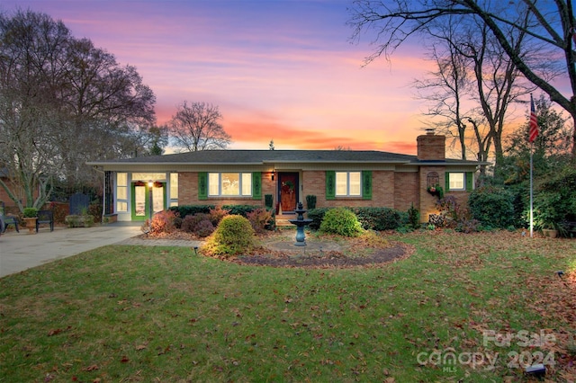 single story home featuring a lawn