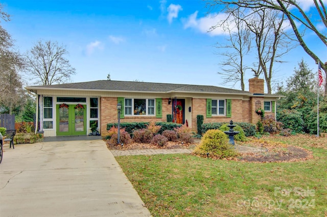 ranch-style home with french doors and a front yard