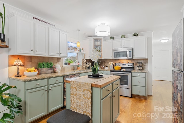 kitchen with a center island, appliances with stainless steel finishes, sink, and white cabinets