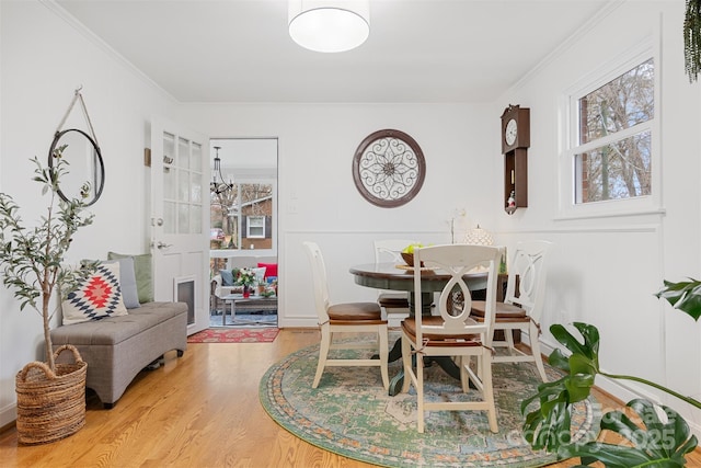 dining space with crown molding and wood-type flooring