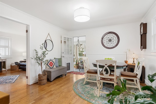 dining space with plenty of natural light, ornamental molding, and wood-type flooring