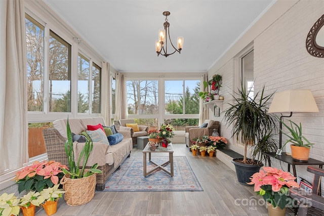 sunroom / solarium featuring a notable chandelier