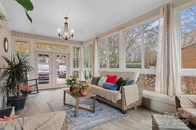 sunroom / solarium featuring french doors and a chandelier