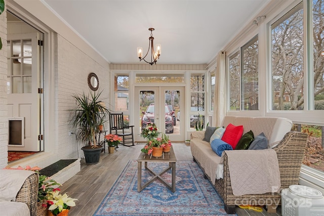 sunroom with a wealth of natural light, french doors, and a chandelier