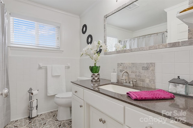 bathroom with tile patterned floors, toilet, tile walls, ornamental molding, and vanity