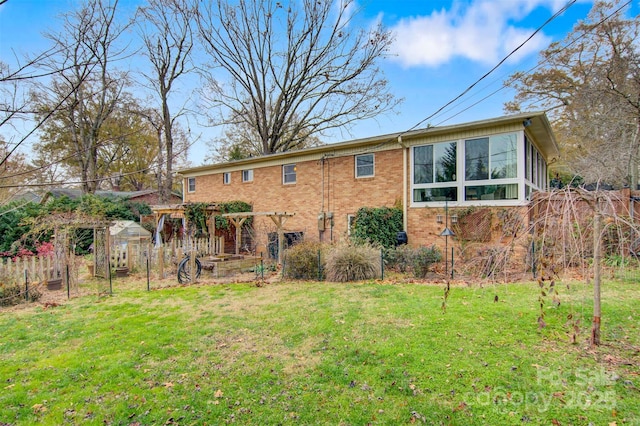 back of house with a pergola and a lawn