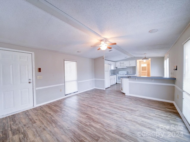 unfurnished living room featuring a textured ceiling, light wood-type flooring, vaulted ceiling, and ceiling fan