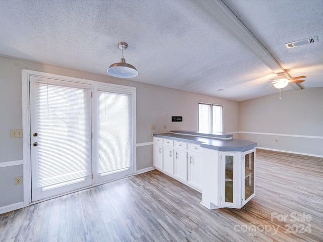 kitchen featuring light wood-type flooring, a textured ceiling, ceiling fan, white cabinets, and hanging light fixtures