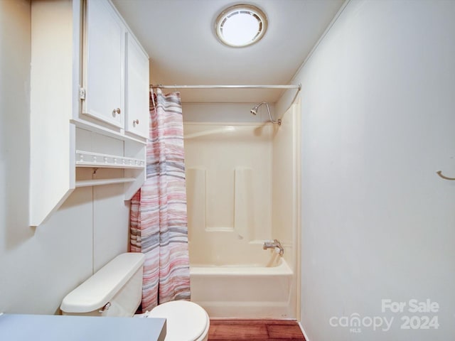 bathroom featuring shower / tub combo, hardwood / wood-style flooring, and toilet