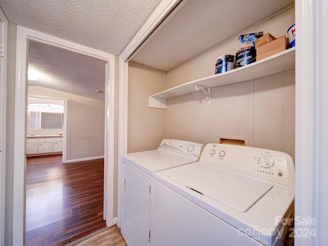 laundry area with hardwood / wood-style floors, a textured ceiling, and independent washer and dryer