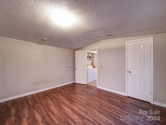 interior space featuring washer and clothes dryer, dark hardwood / wood-style floors, lofted ceiling, and a textured ceiling