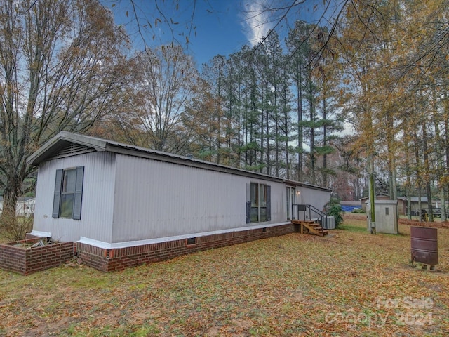 view of home's exterior featuring central AC unit and a shed