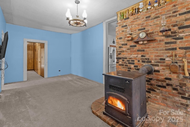 interior space featuring a chandelier, a textured ceiling, and a wood stove