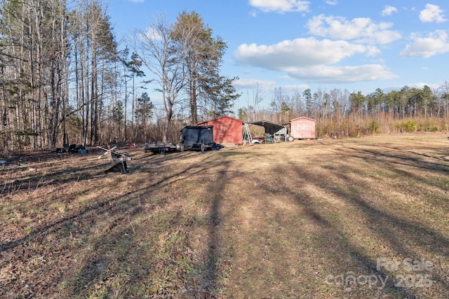 view of yard with a carport and an outdoor structure