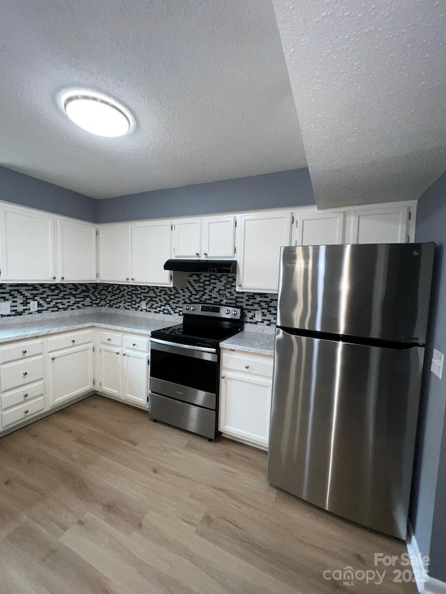 kitchen with white cabinets, a textured ceiling, stainless steel appliances, and light hardwood / wood-style floors