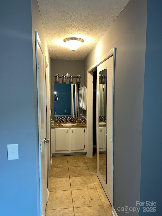 hall with a textured ceiling and sink