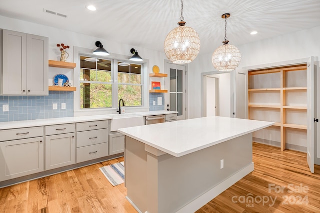 kitchen with dishwasher, light hardwood / wood-style flooring, a notable chandelier, and gray cabinetry