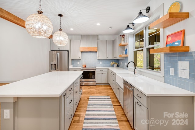 kitchen featuring custom exhaust hood, a center island, sink, light wood-type flooring, and appliances with stainless steel finishes