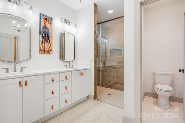 bathroom with tile patterned flooring, vanity, an enclosed shower, and toilet