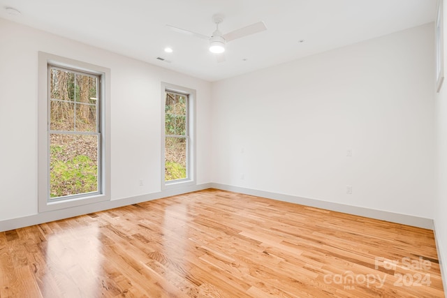 empty room featuring light hardwood / wood-style flooring, ceiling fan, and a healthy amount of sunlight