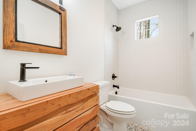 full bathroom with vanity, tiled shower / bath combo, and toilet