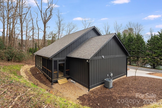 view of side of property with a sunroom and central air condition unit